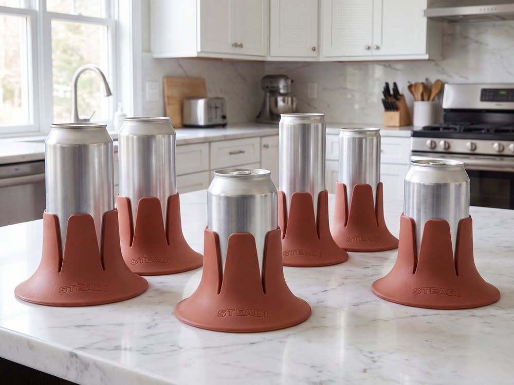 Six Copper Steadi bases holding cans of different sizes, lined up on a kitchen counter.